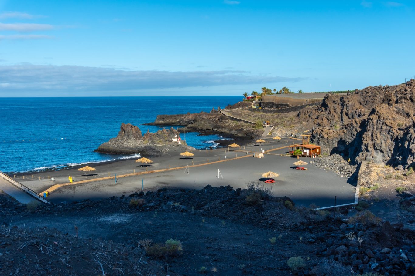 La Palma - Strand Charco Verde bei Puerto Naos Felsen mit Naturstrand und Badegästen in Charco Verde
