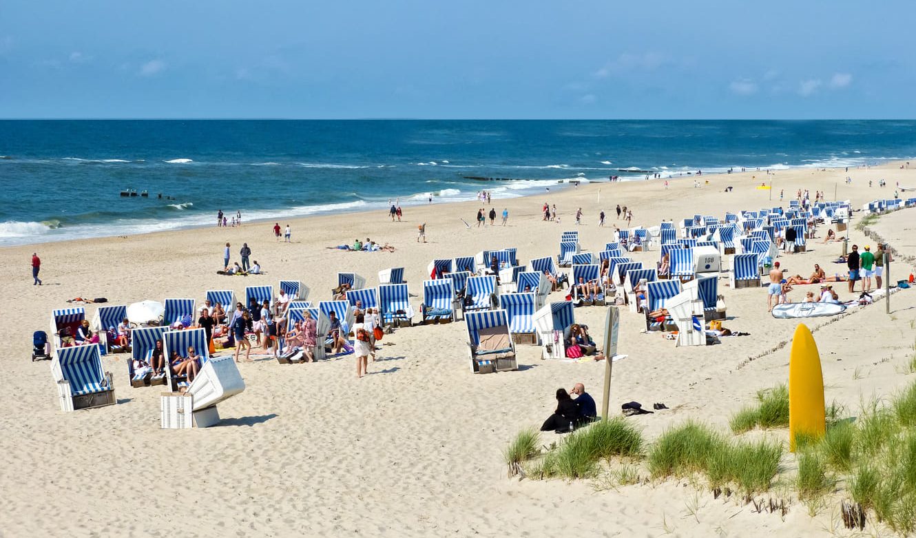 Urlauber und Strandkörbe am Strand in Sylt