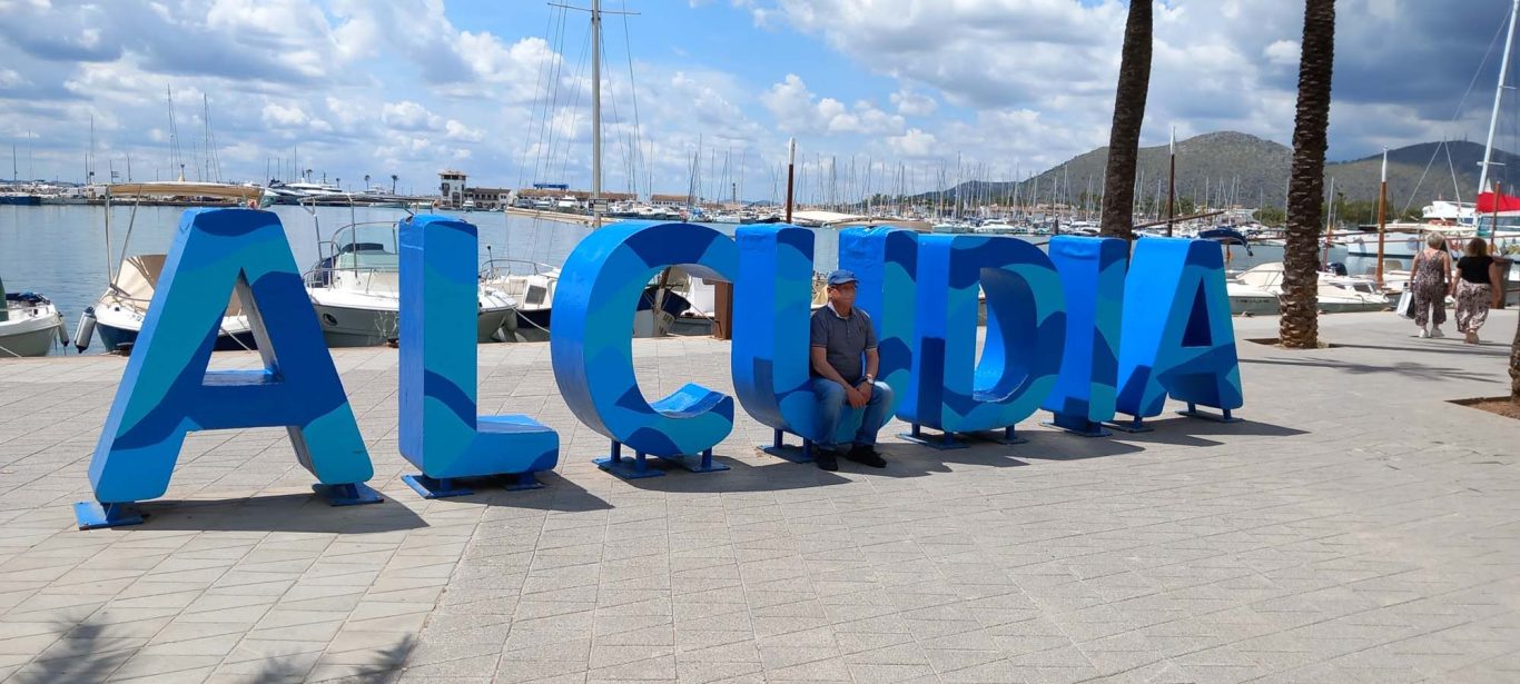 Alcúdia Buchstaben im Hafen als Fotomotiv Bunte Buchstaben "ALCUDIA" am Hafen mit Booten im Hintergrund.