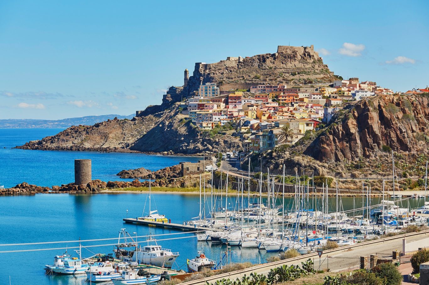 Sardinien - Castelsardo Hafen und bunte Felsenstadt Blick über den Hafen auf einen Berg mit bunten Häusern auf Sardinien