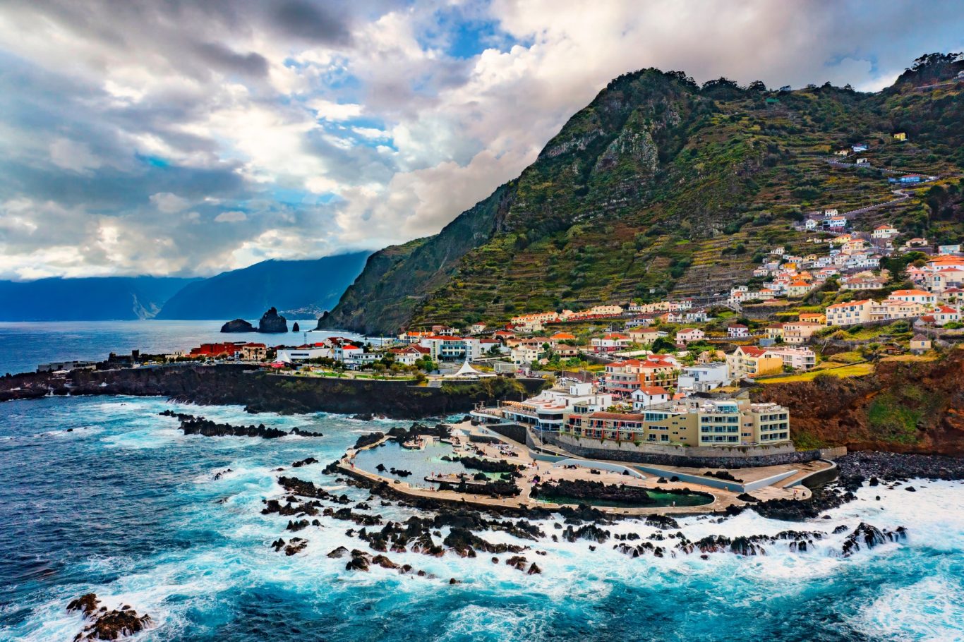 Madeira - Blick auf Porto Moniz im Nordwesten Luftbild von Porto Moniz mit Brandung, Stadt und Bergen auf Madeira