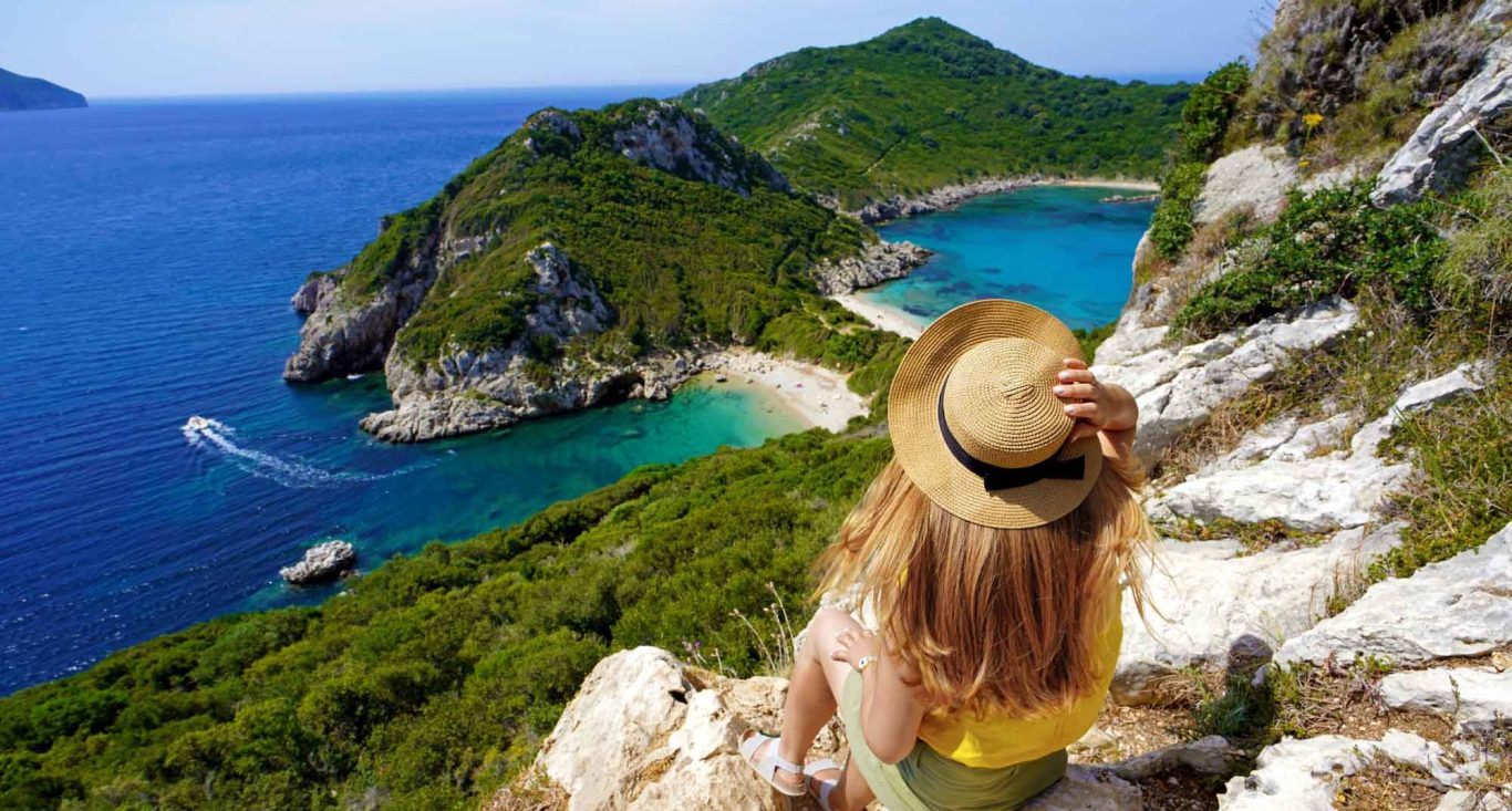 Frau sitzend blickt auf Strand Porto Timoni auf Korfu