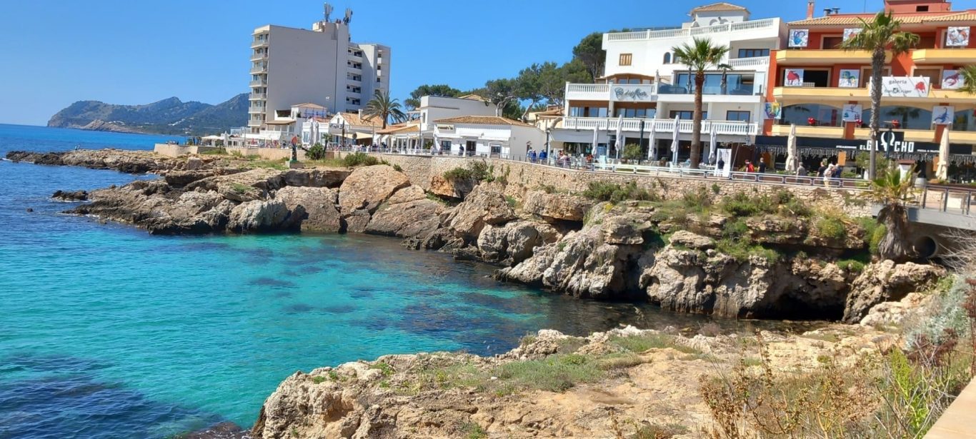 Hafeneinfahrt mit Promenade in Cala Ratjada Felsen und Häuser an der Promenade