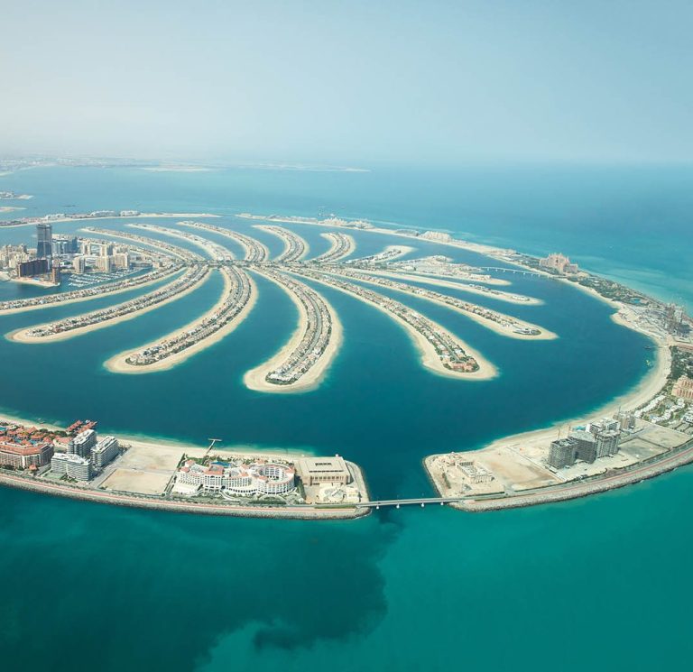 Luftaufnahme einer künstlichen Insel mit Palmblatt-ähnlicher Form und türkisfarbenem Wasser.